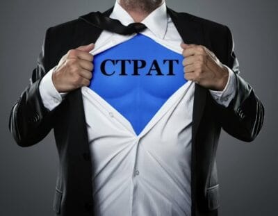 Businessman revealing a blue 'CTPAT' emblem like a superhero symbol.
