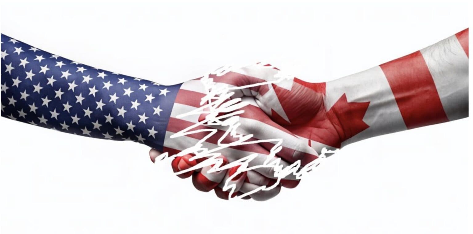 Shaking hands with American and Canadian flags, symbolizing trade relations.