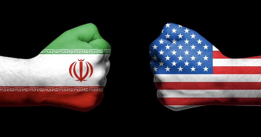 Iran and USA flags painted on fists facing each other.
