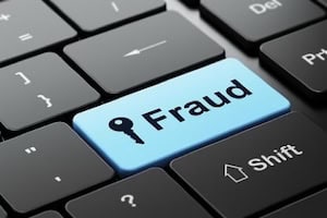 Blue key with 'Fraud' label on a keyboard for trade enforcement.