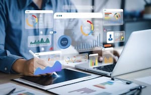 Business professional analyzing financial data on digital screens.