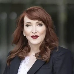 Legal professional woman with red hair in formal attire.
